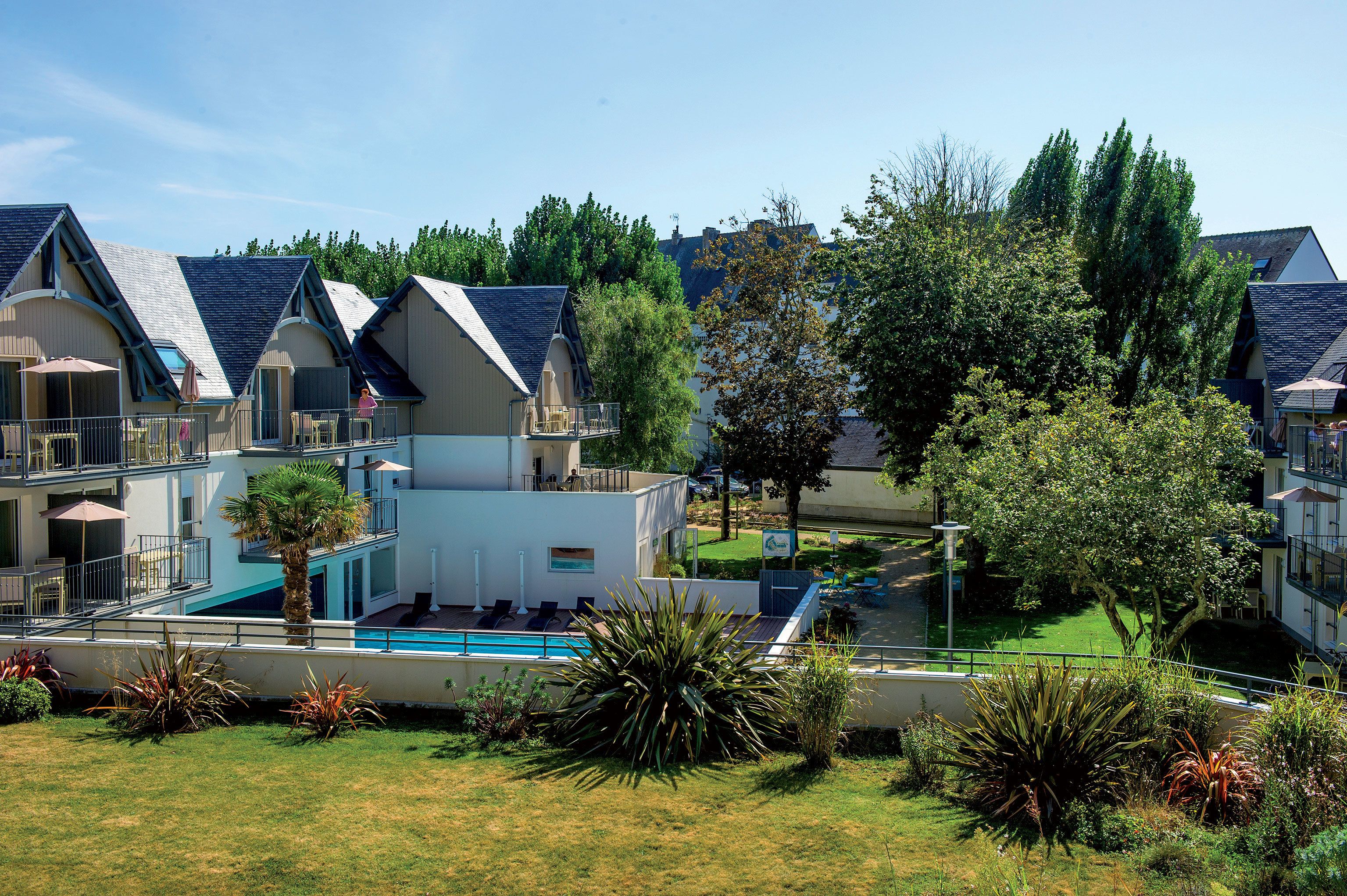 A resort with multiple buildings, a swimming pool, and well-maintained landscaping.