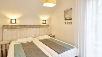 Ein Doppelbett mit Holz-Kopfteil, zwei Nachttische und ein Wandbild.