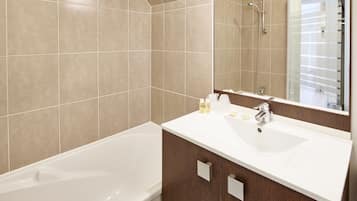 Een aparte badkuip en douche, gratis toiletartikelen, een haardroger