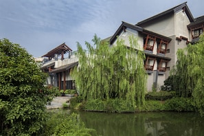 A traditional-style building with a water feature in front. - Angsana Hangzhou (Hangzhou)