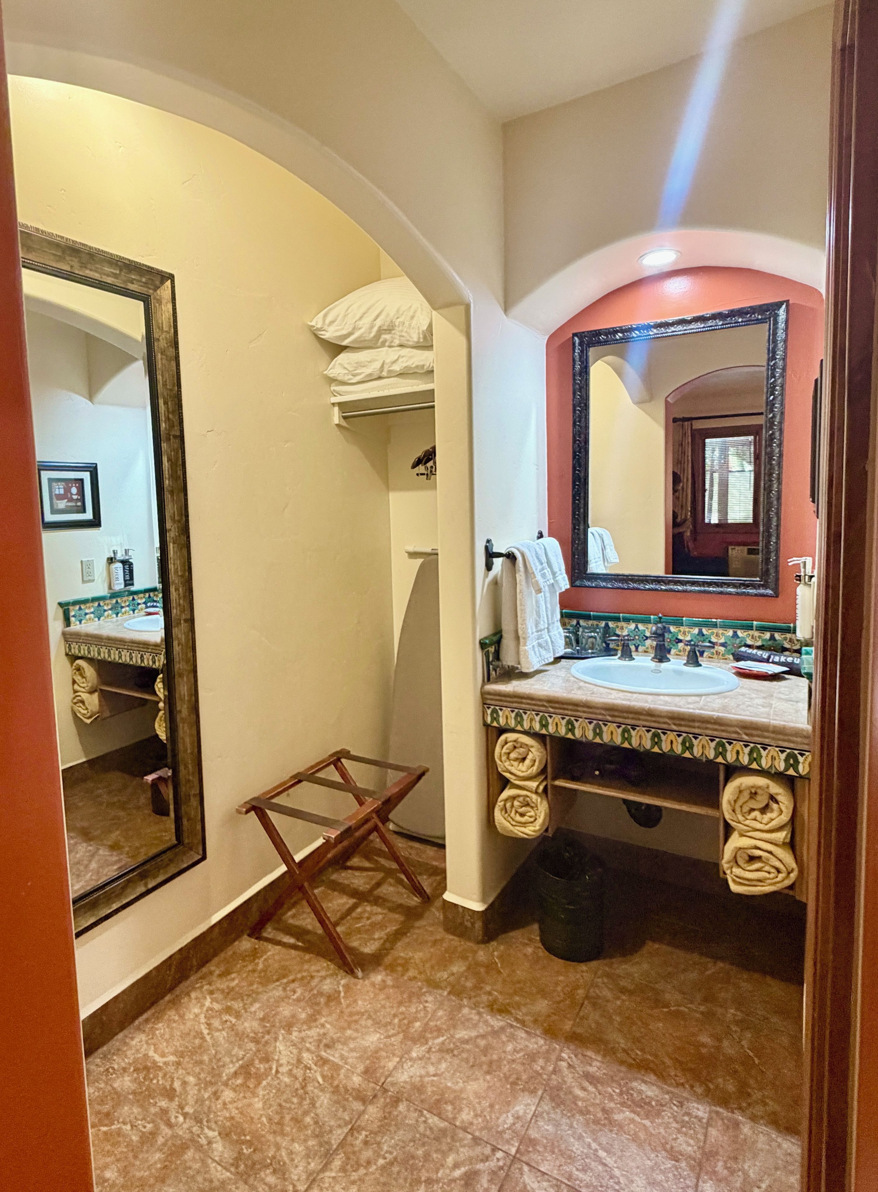 A bathroom with a sink, mirror, and towel rack.