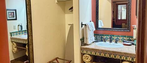 A bathroom with a sink, mirror, and towel rack.