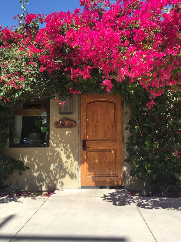 A building with a wooden door and a sign reading "FRONT DESK".