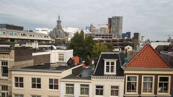 Een stadsgezicht met een combinatie van historische en moderne gebouwen, waaronder een opvallende toren en een bouwplaats.