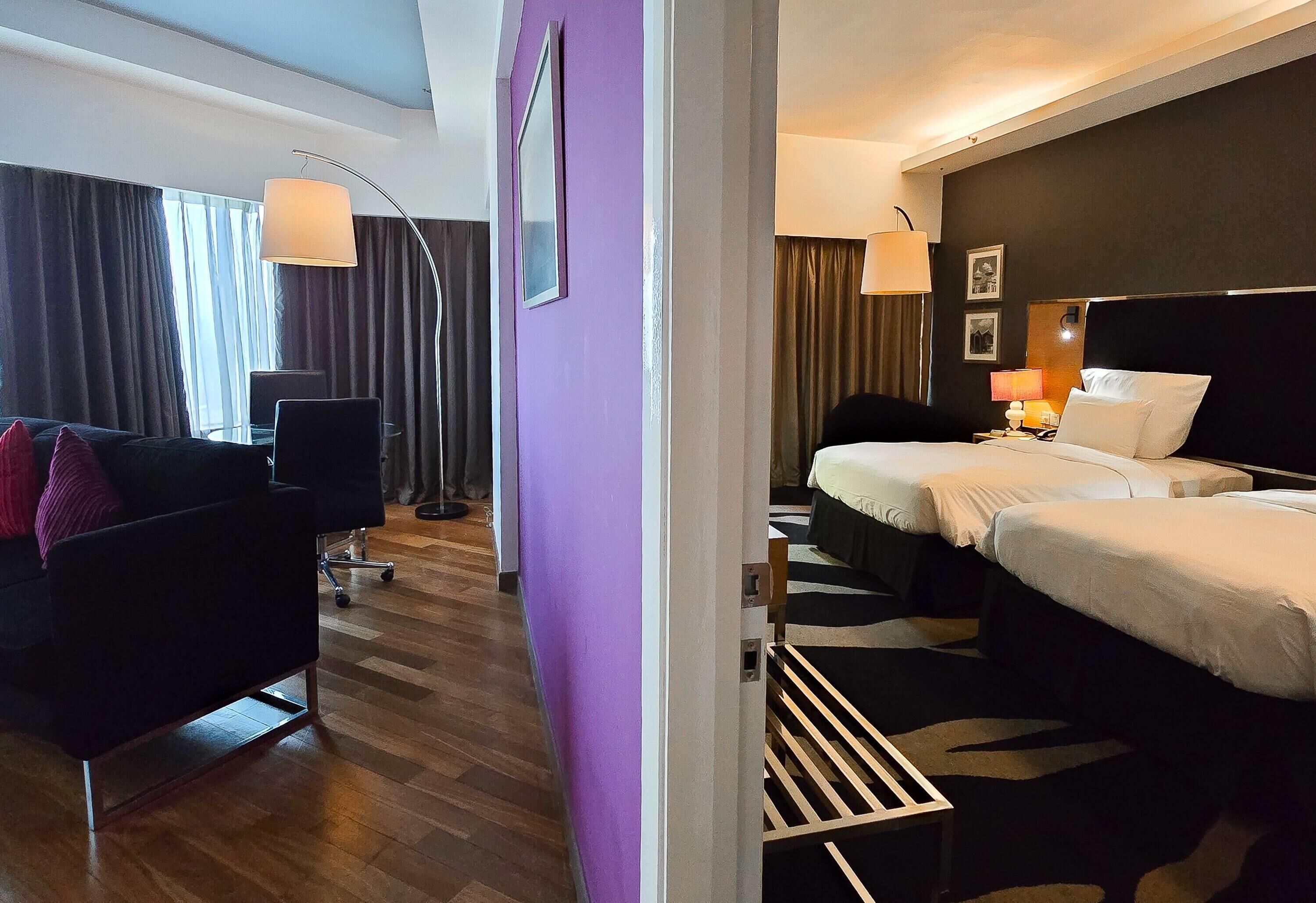 Una habitación de hotel con cama, escritorio, silla y sofá.