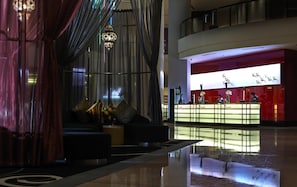 A modern lobby with a reception desk, seating area, and a decorative hanging light fixture. - Wyndham Grand Bangsar Kuala Lumpur (Kuala Lumpur)