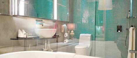 Un baño moderno con ducha envuelta en vidrio, una bañera blanca y un espejo grande.
