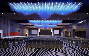 A conference room with rows of chairs, a large screen, and a ceiling light installation. - Wyndham Grand Bangsar Kuala Lumpur (Kuala Lumpur)