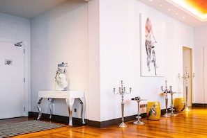 A modern interior with a reception desk, a large abstract painting, and a row of decorative candelabras. - Wyndham Grand Bangsar Kuala Lumpur (Kuala Lumpur)