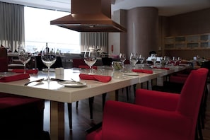 A restaurant with a long table set for dining, red chairs, and wine glasses. - Wyndham Grand Bangsar Kuala Lumpur (Kuala Lumpur)