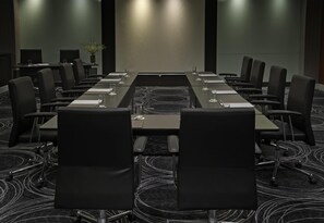 A conference room with a long table, black chairs, and a carpeted floor. - Wyndham Grand Bangsar Kuala Lumpur (Kuala Lumpur)
