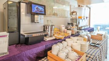 Ein Buffet mit Kaffeemaschine, einer Karte an der Wand sowie verschiedenen Behältern für Speisen und Getränke.