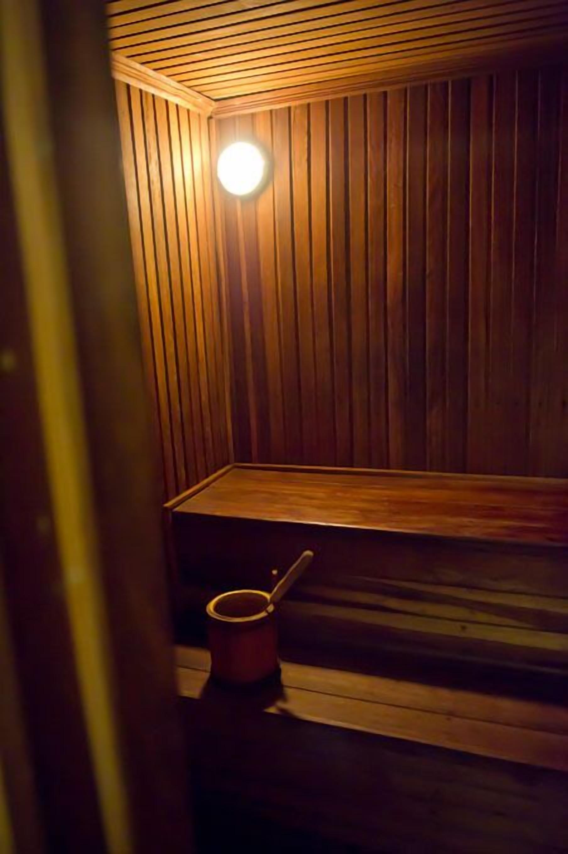 Una sauna con paredes de madera y un banco.