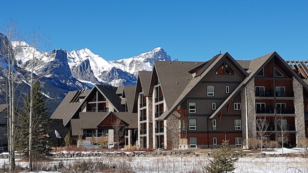 A multi-story building with a ski lodge and mountain views. - Paradise Resort Club and Spa (Canmore)