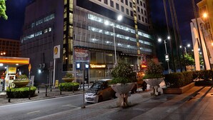 A hotel with a modern design, featuring a prominent sign at the top and multiple floors with illuminated windows. - Horizon Hotel (Kota Kinabalu)