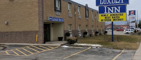 A building with a sign reading "Luxury Inn" and another sign stating "Newly Renovated Best Rates High-Speed Internet".