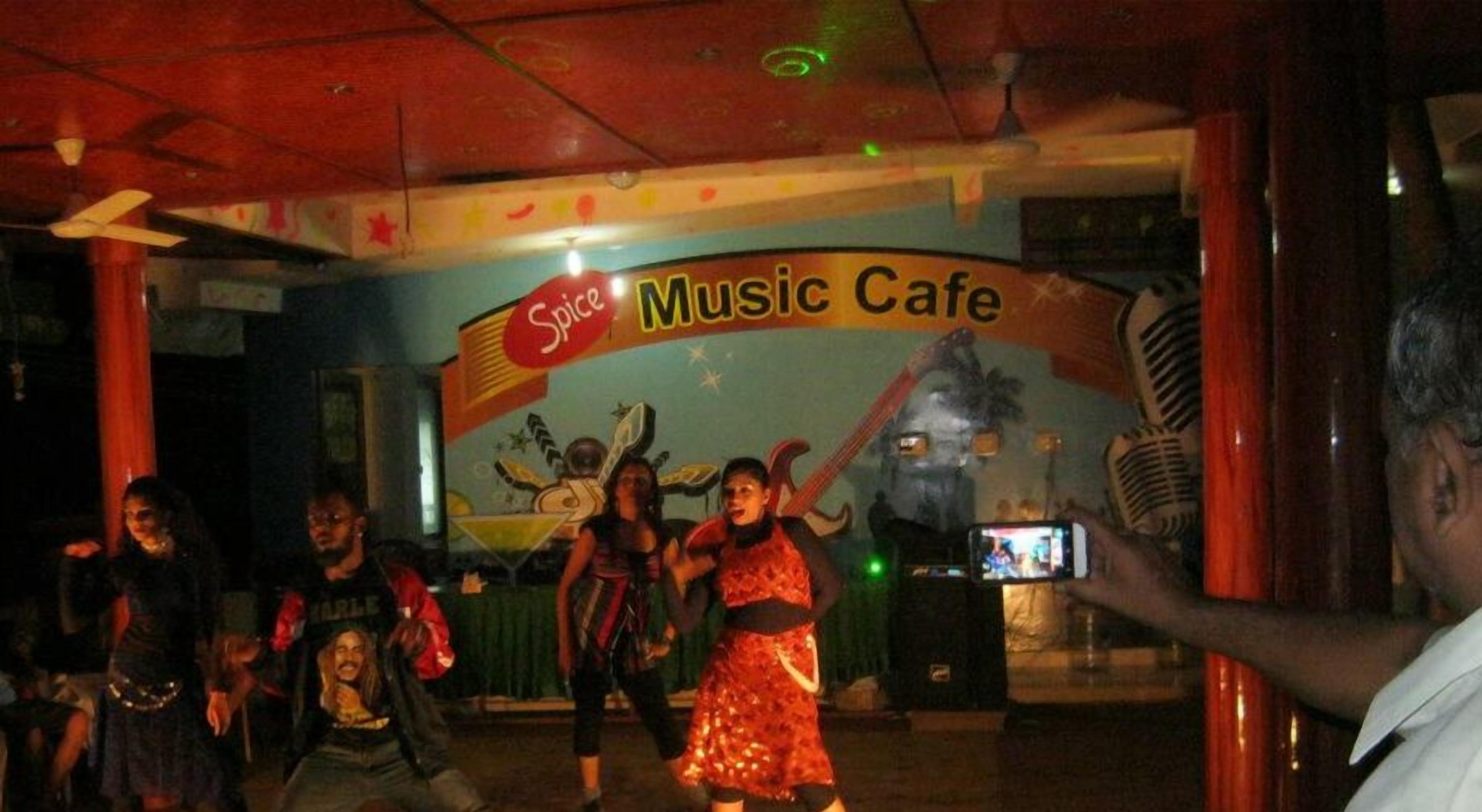 A Spice Music Cafe with a vibrant mural and a ceiling fan.
