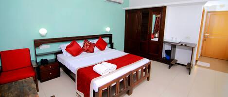 A bedroom with a bed, a desk, a chair, and a wardrobe.