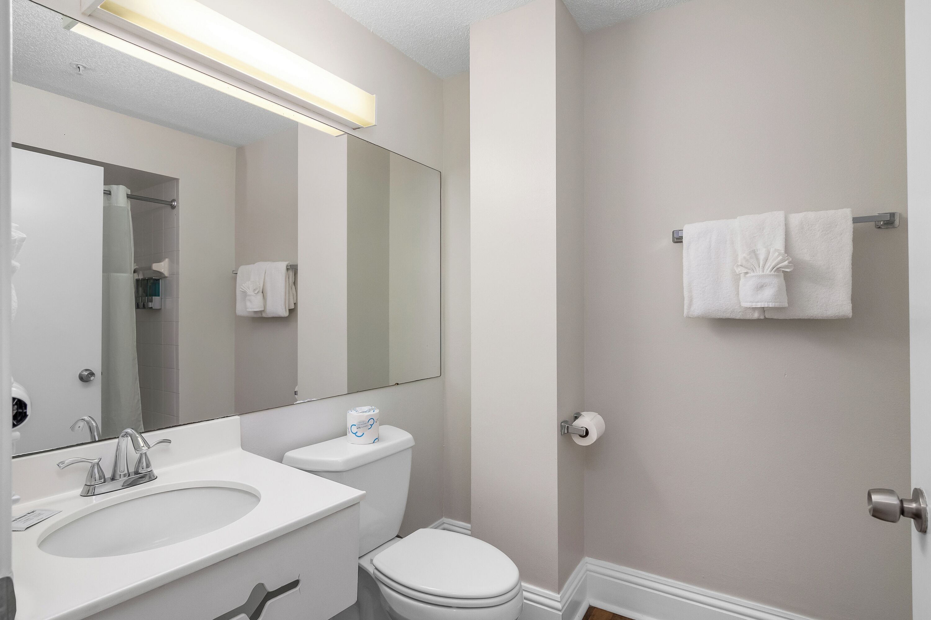 Une salle de bain moderne avec un lavabo blanc, un miroir et des toilettes.