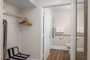 A compact bathroom with a shower, toilet, and a mirror. - Naples Park Central Hotel (Naples)