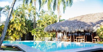 Una piscina al aire libre, sillones reclinables de piscina