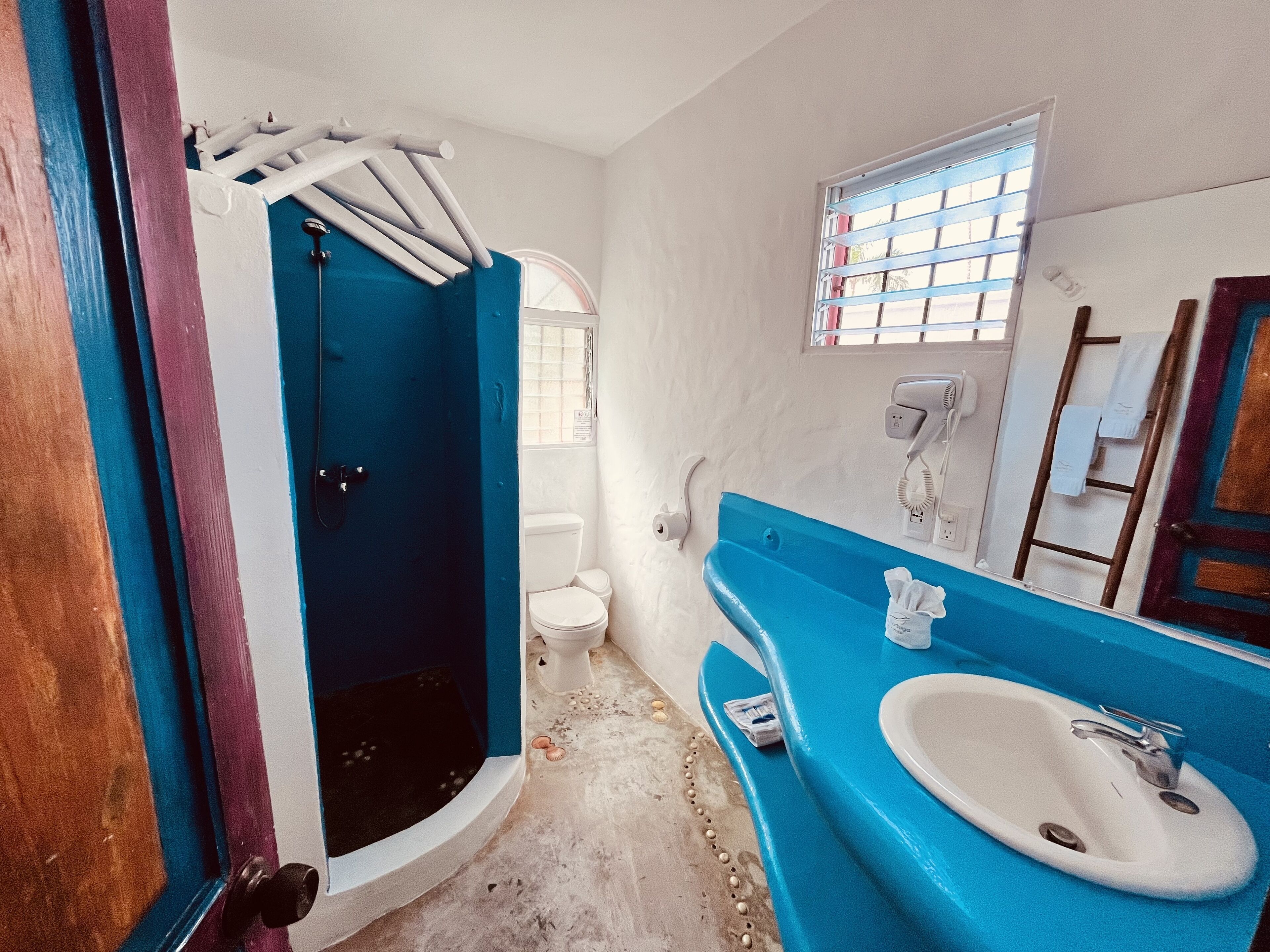 A bathroom with a blue bathtub, a white sink, and a toilet.