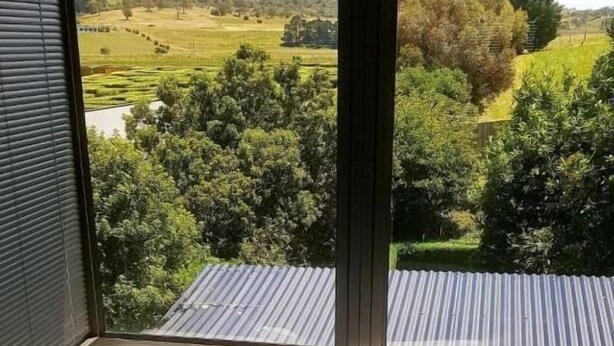 A hot tub with a view of a green landscape through large windows. - Red Brier Cottage Accommodation (Richmond)