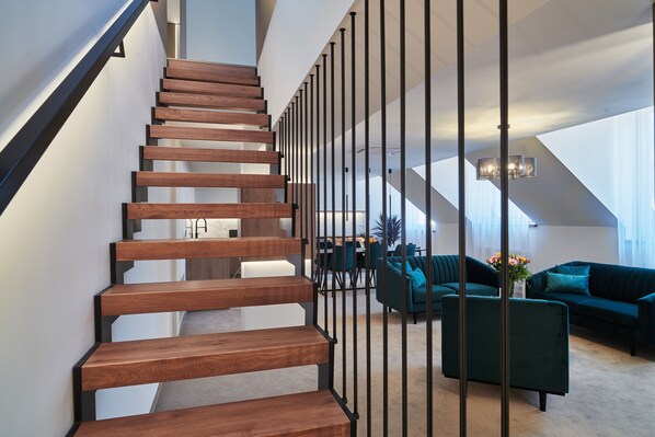 Suite Deluxe | Área de sala de estar | Televisión de pantalla plana de 55 pulgadas con canales digitales