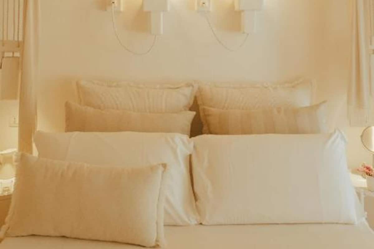 Ein Schlafzimmer mit einem Bett, Kissen und Wandleuchten.