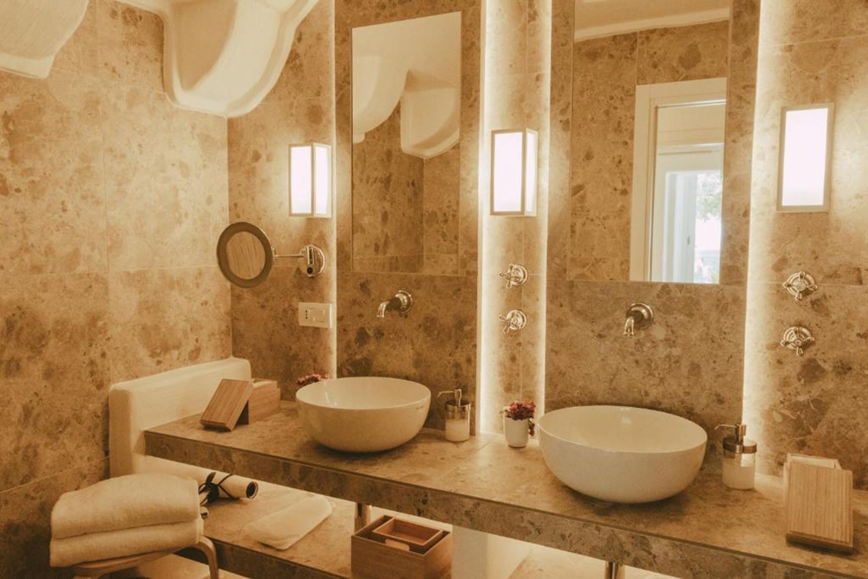A bathroom with two large sinks, a mirror, and a towel rack.