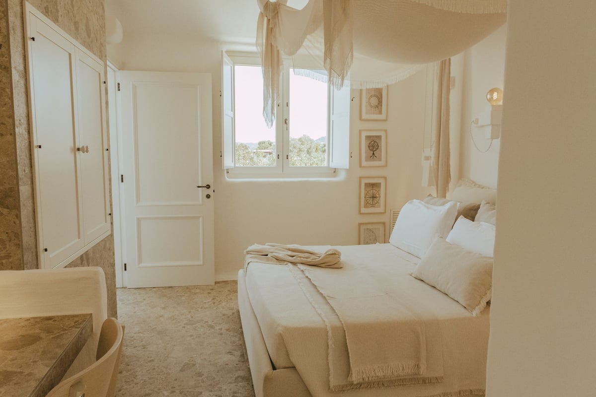 Ein Schlafzimmer mit Bett, Fenster und Tür.