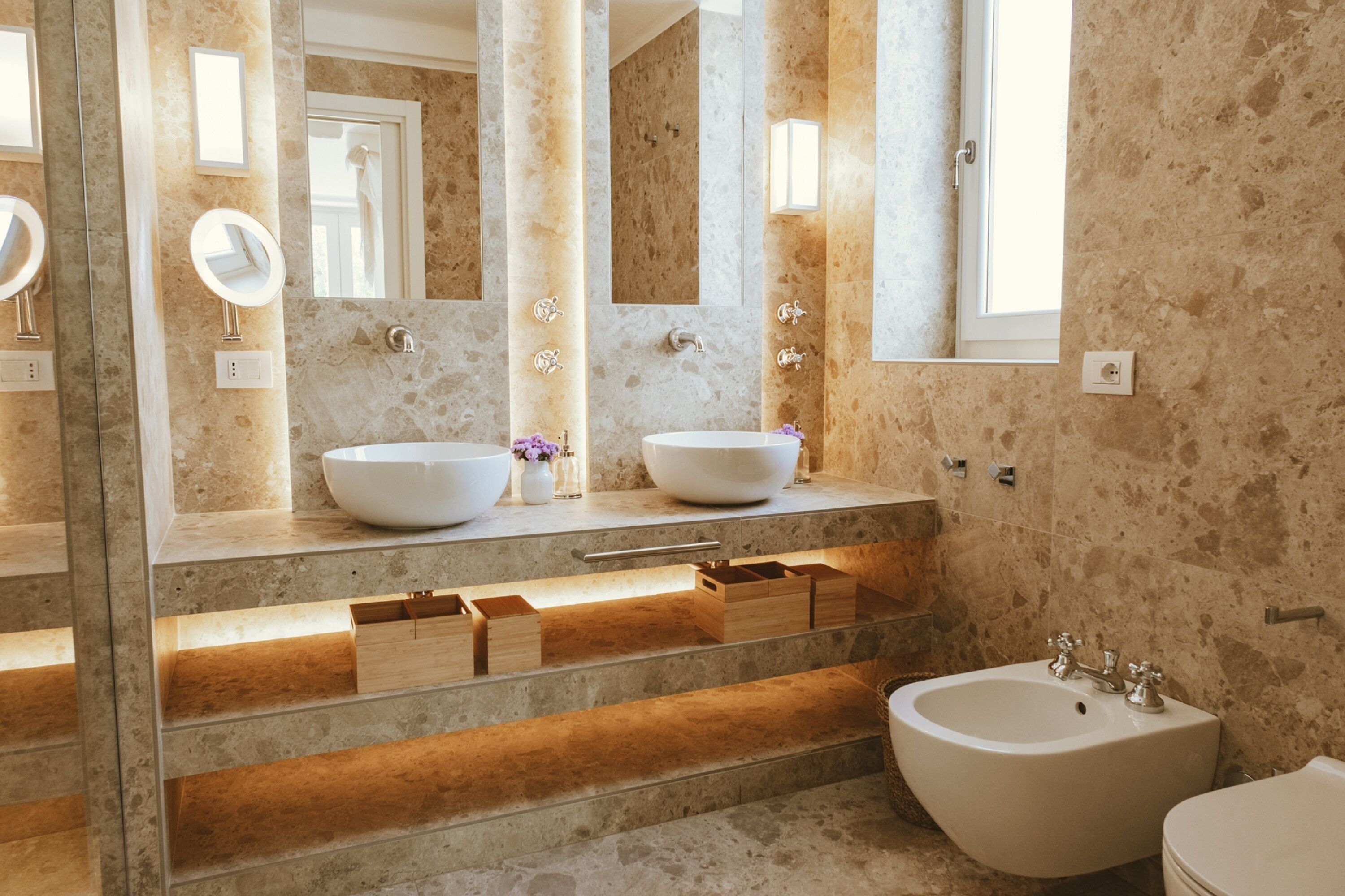 A modern bathroom with two large sinks, a bathtub, and a vanity with drawers.