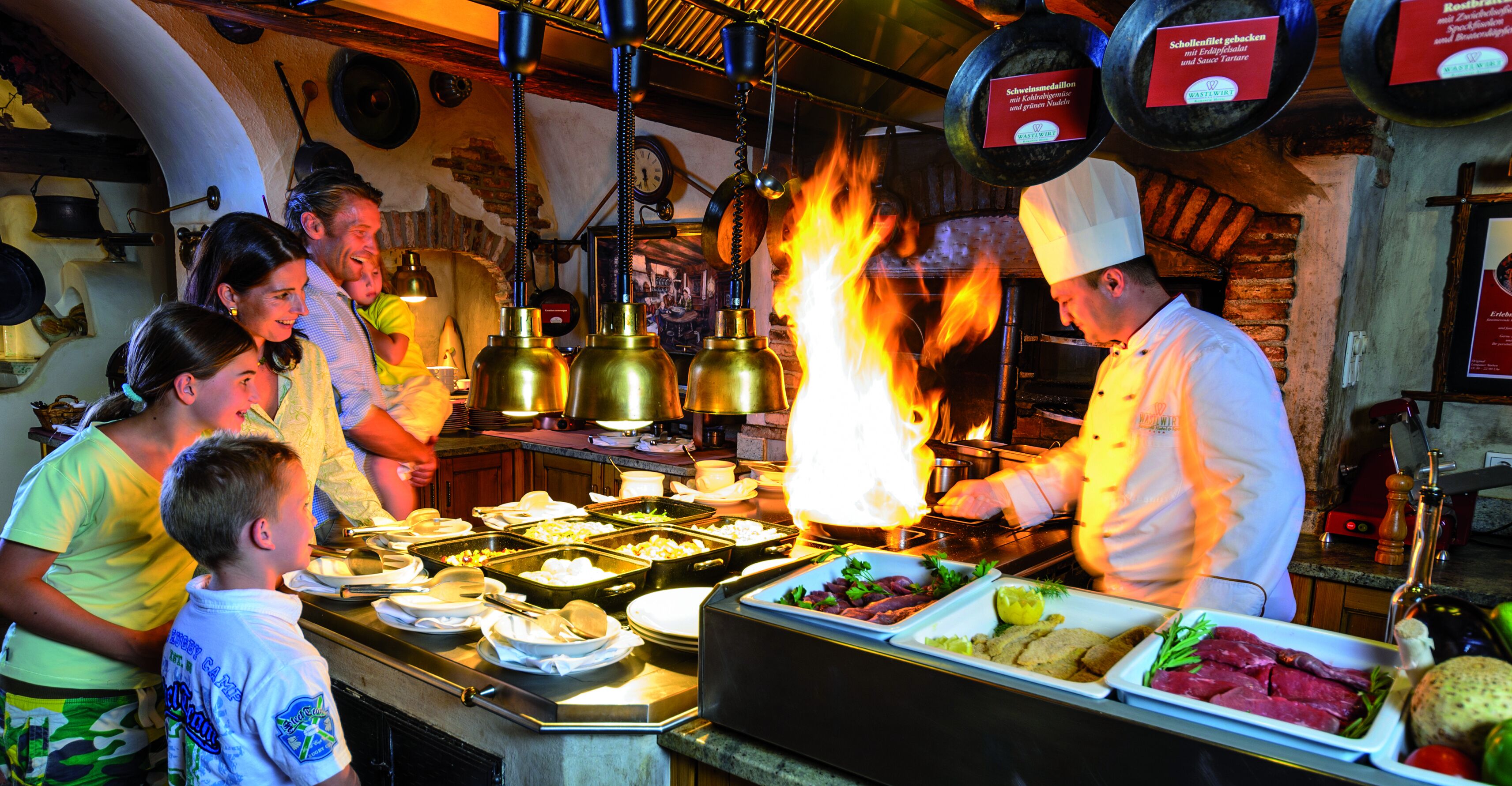 Un chef cuisinant avec une grande flamme dans une cuisine rustique.