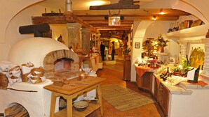 Eine rustikale Küche mit einem Holzofen, einem Holztisch und diversen Küchenutensilien.
