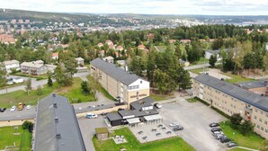 A hotel with a central courtyard, parking area, and surrounding residential buildings.