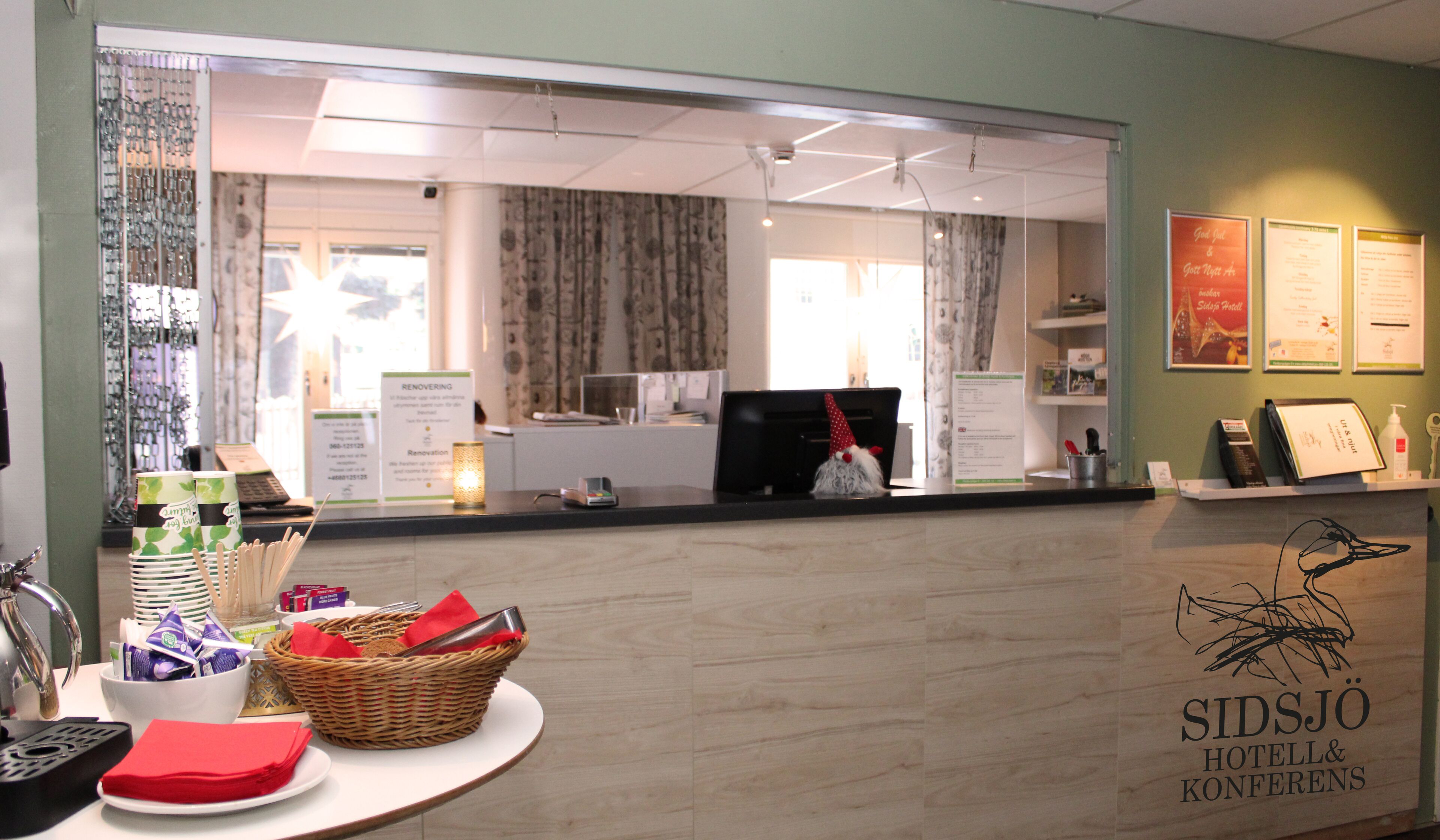 A reception area with a counter, a wicker basket, and a sign for SIDSJÖ HOTELL & KONFERENS.