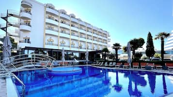 Ein Hotel mit Schwimmbad, mehreren Balkonen und Sitzgelegenheiten im Freien.