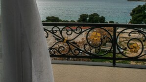 A balcony with a view of a body of water and distant land. - Hotel Miramare (Vodice)