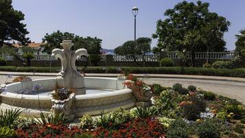 A fountain with a tiered design surrounded by a variety of colorful flowers and plants.