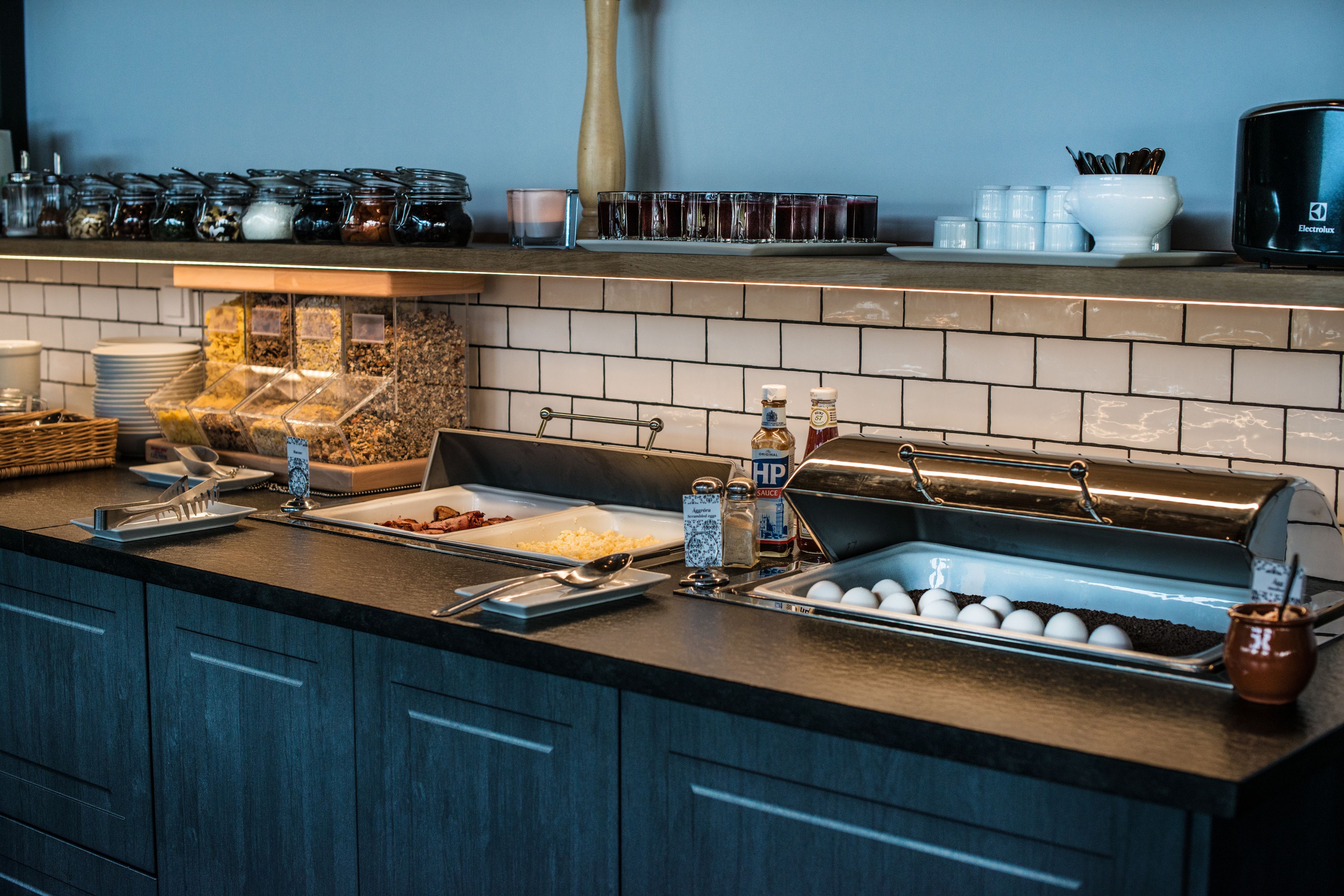 A buffet setup with various food items, condiments, and utensils.