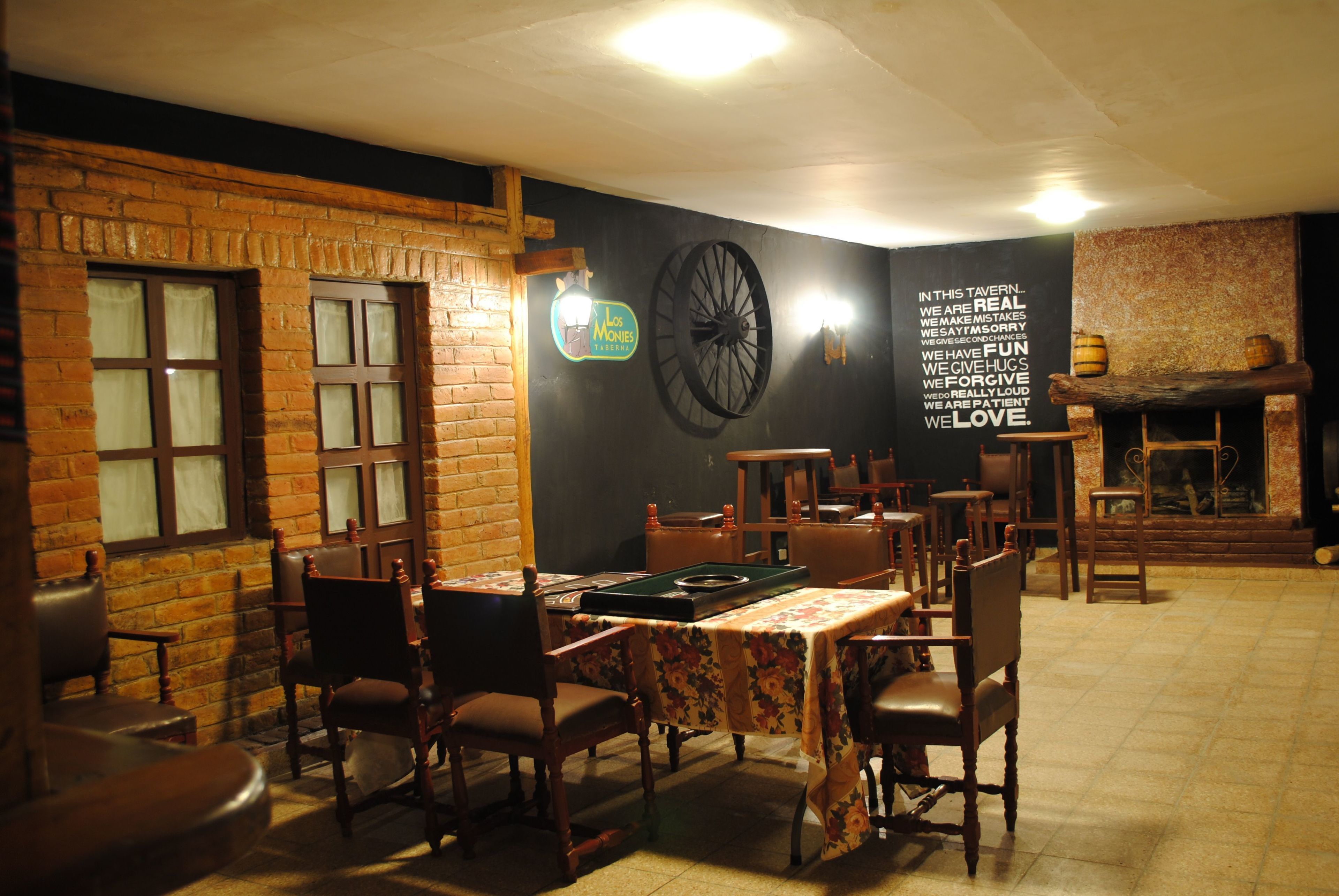 Un restaurante acogedor con paredes de ladrillo, muebles de madera y una pizarra con un mensaje positivo.