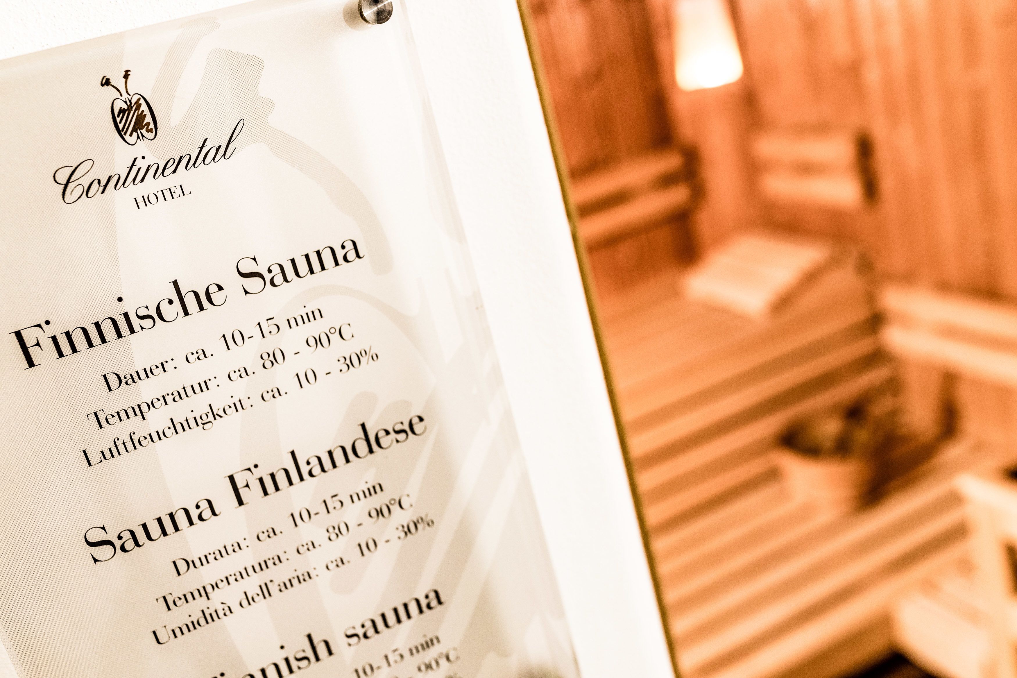 A menu listing Finnische Sauna and Sauna Finlandese with durations of 10-15 minutes, temperatures of 80-90°C, and humidity levels of 10-30%.