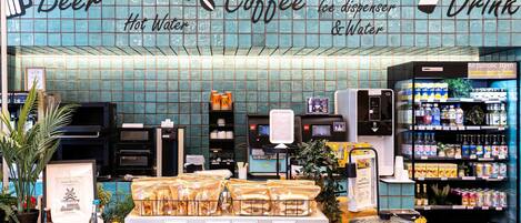 A beverage kiosk with a sign reading 'Beer Coffee Hot Water & Water' and a refrigerated display of alcoholic items.