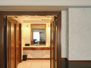 Ein Badezimmer mit einem Holzbadschrank, einem Spiegel und einem Waschbecken.
