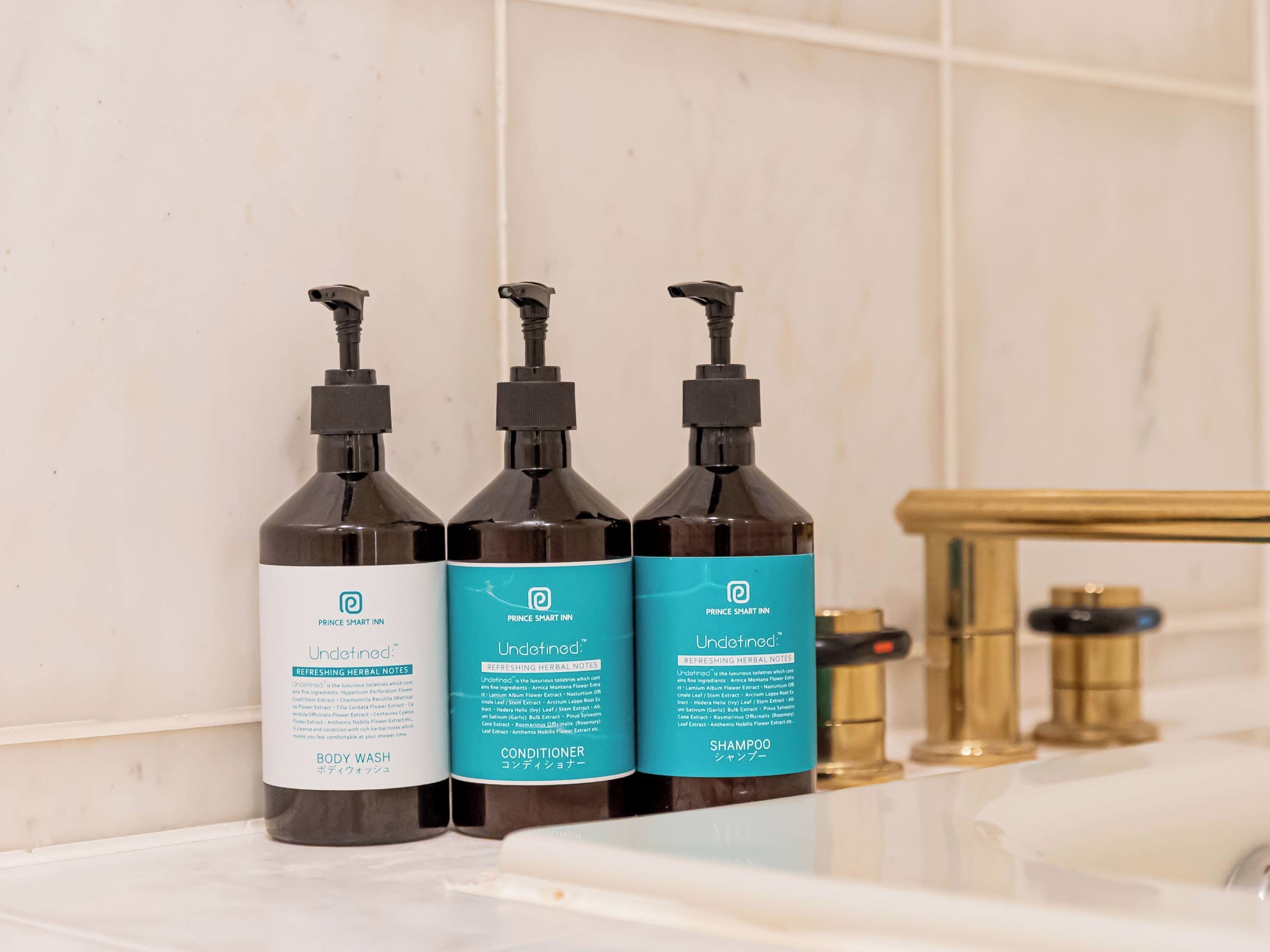 Three bottles of Prince Smart Inn Undefined body wash on a bathroom counter.