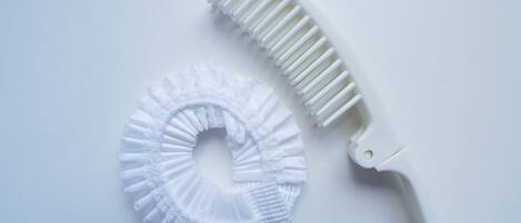 Un cepillo de dientes blanco y un dispensador de hilo dental blanco.