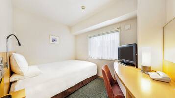 Una camera d'albergo con un letto singolo, una scrivania con un computer, una sedia, una televisione e una finestra con tende.