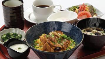 A tray with various dishes including a bowl of rice, a bowl of soup, a cup of tea, a small bowl of pickled vegetables, and a plate of salad.