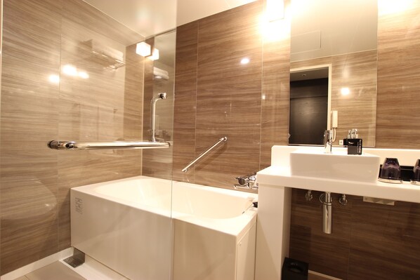 Un baño moderno con ducha envuelta en vidrio, una bañera blanca y un lavamanos con espejo y lavabo.
