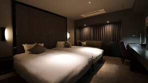 Una habitación de hotel moderna con una cama grande, un escritorio y una silla.